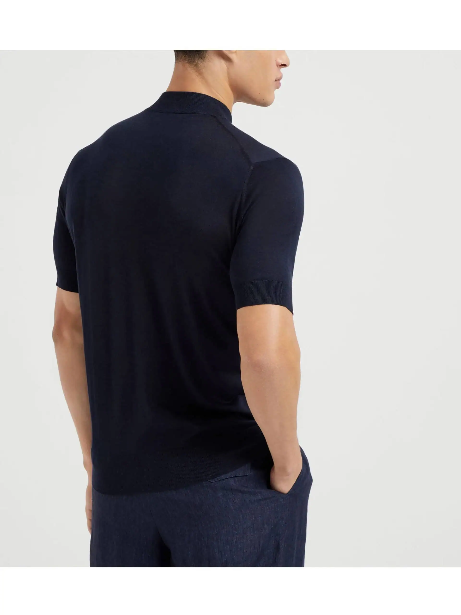 Conjunto de homem com suéter azul escuro e calças elegantes, estilo casual sofisticado.