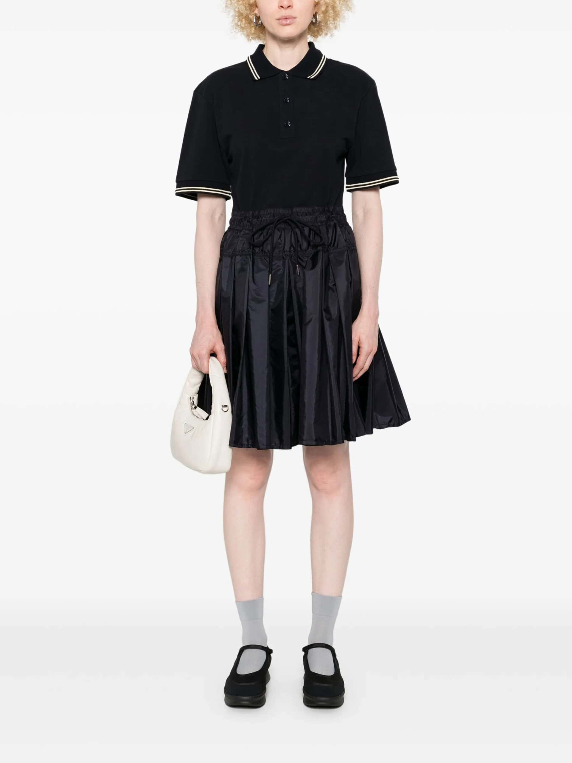 Risca preto de moda feminina e masculina, vestido com saia plissada e acessórios elegantes.