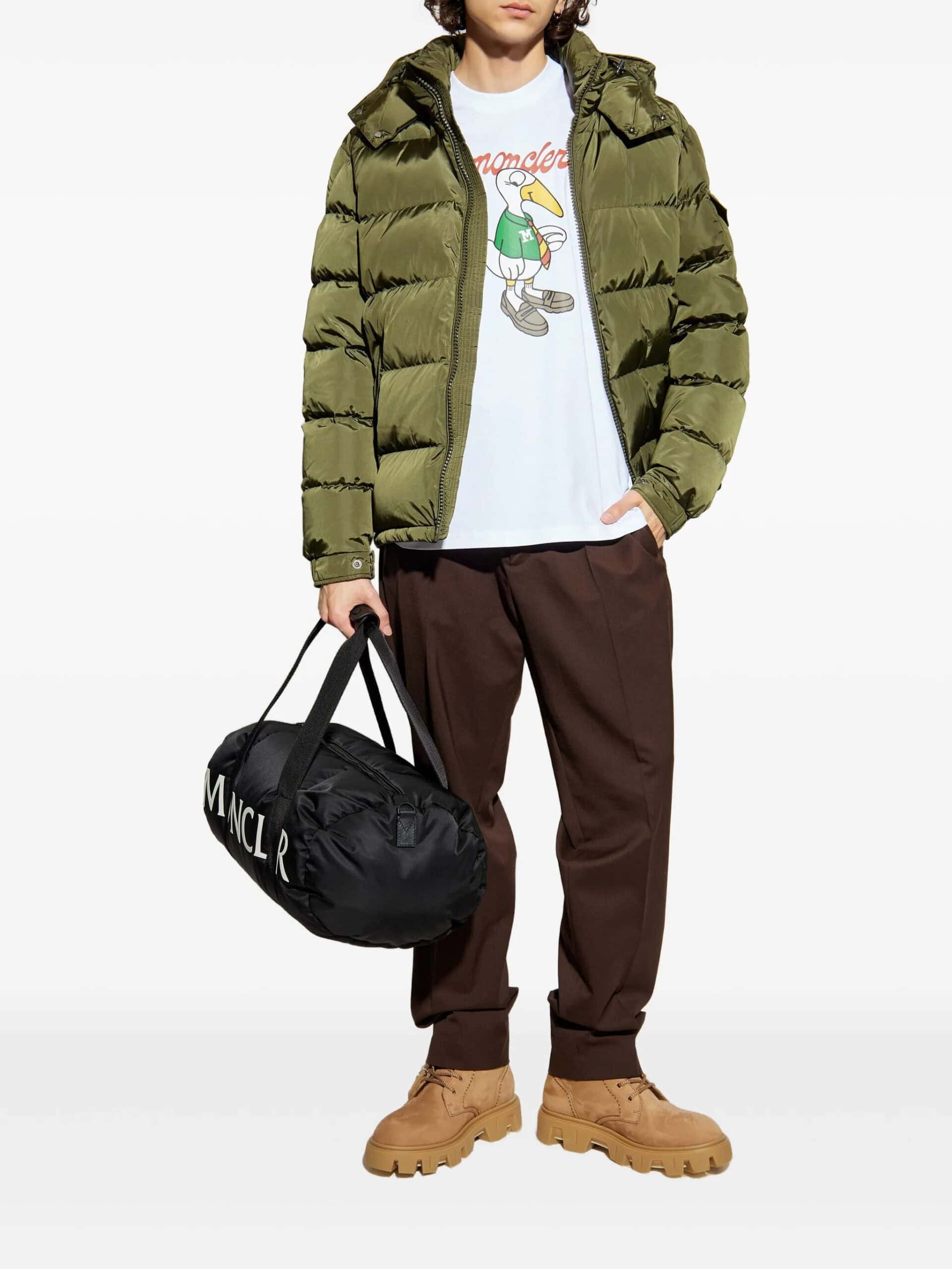 Casaco puffer verde oliva, calças castanho escuro, botas bege e saco de viagem preto com logotipo. Roupas de moda urbana masculina, estilo casual.