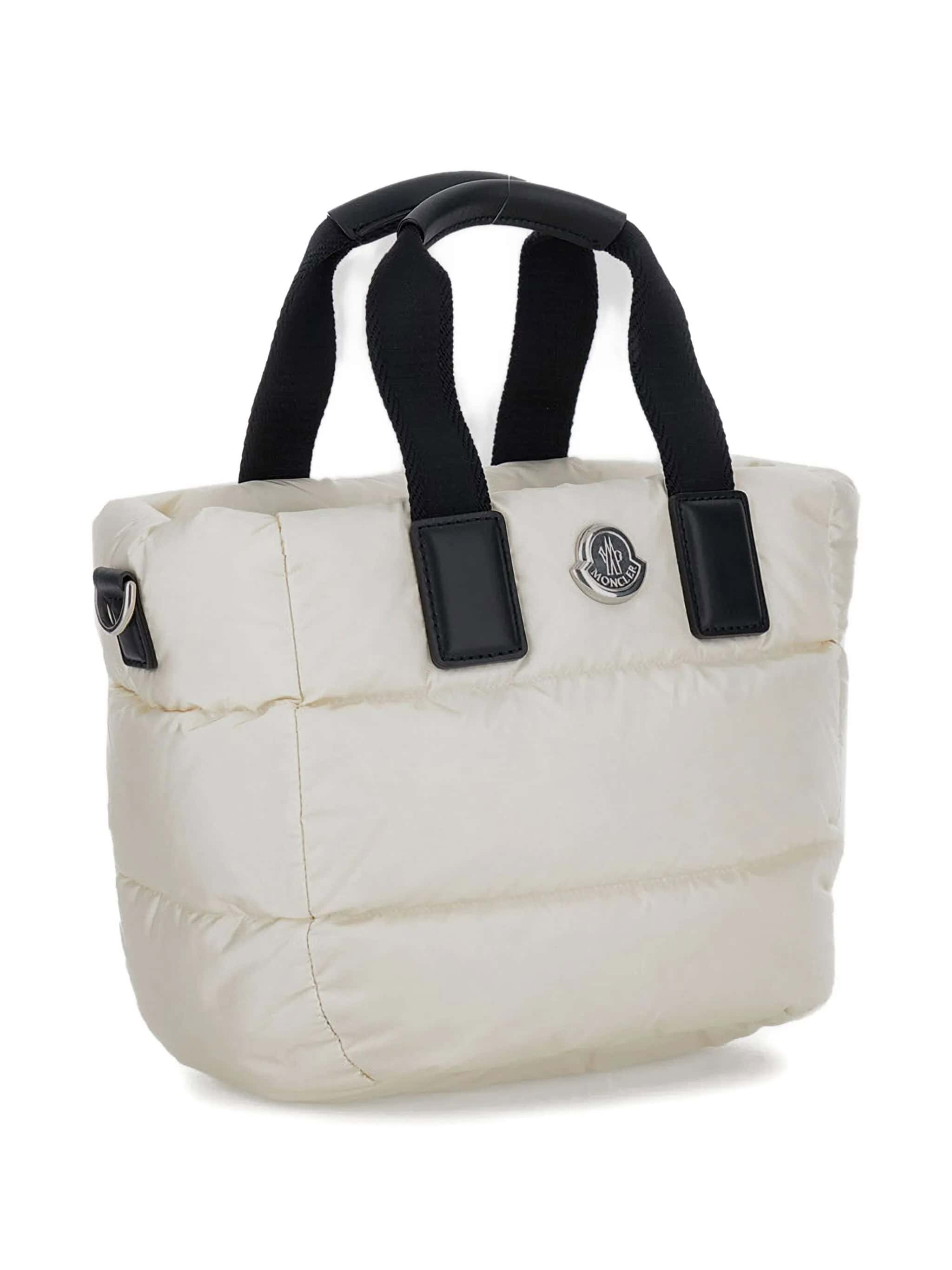 2. Bolsa de inverno Moncler em tom branco com alças pretas, estilo acolchoado e design elegante.