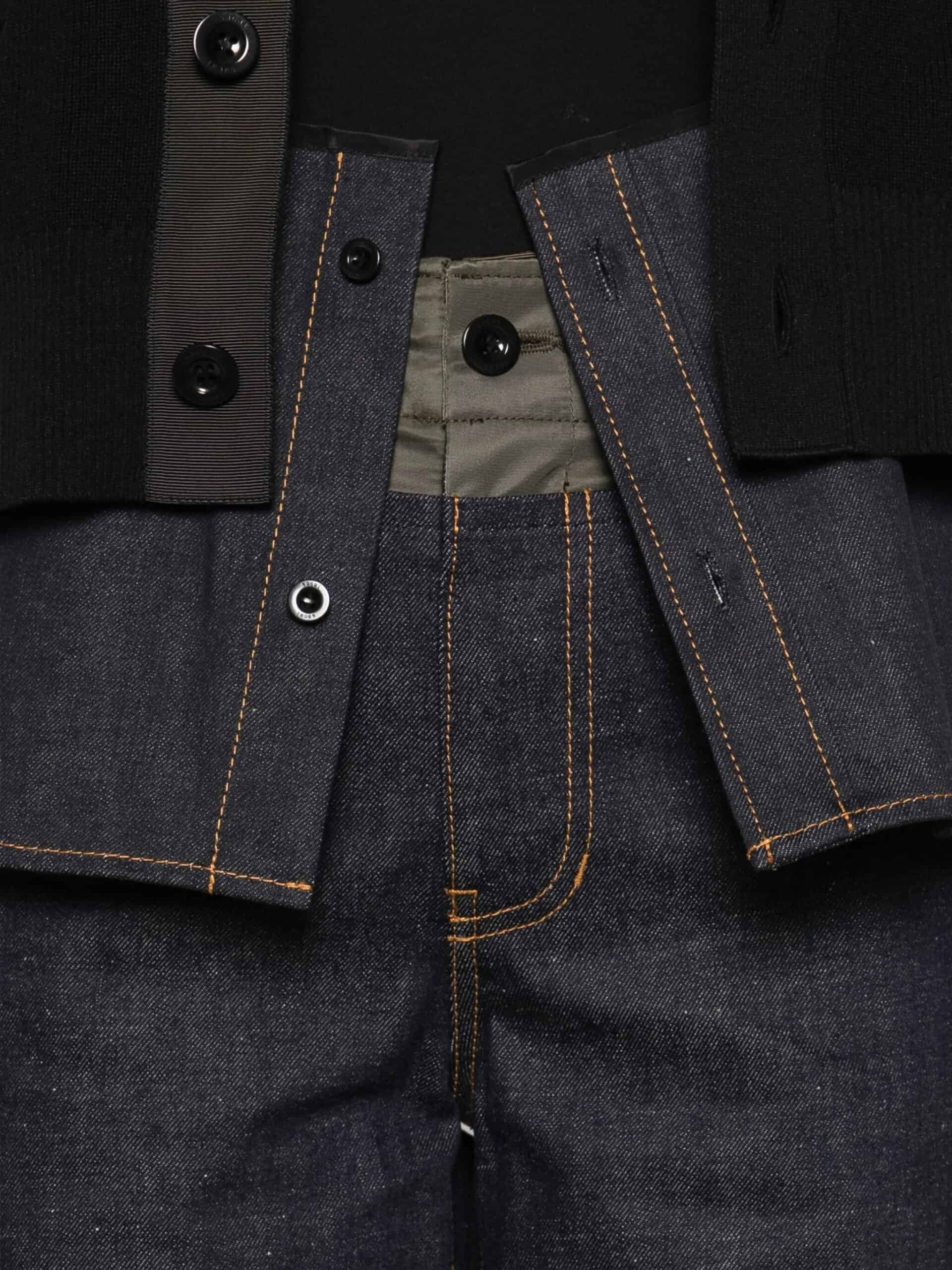 Sofá de couro preto com detalhes em costura dourada, estilo elegante e sofisticado.