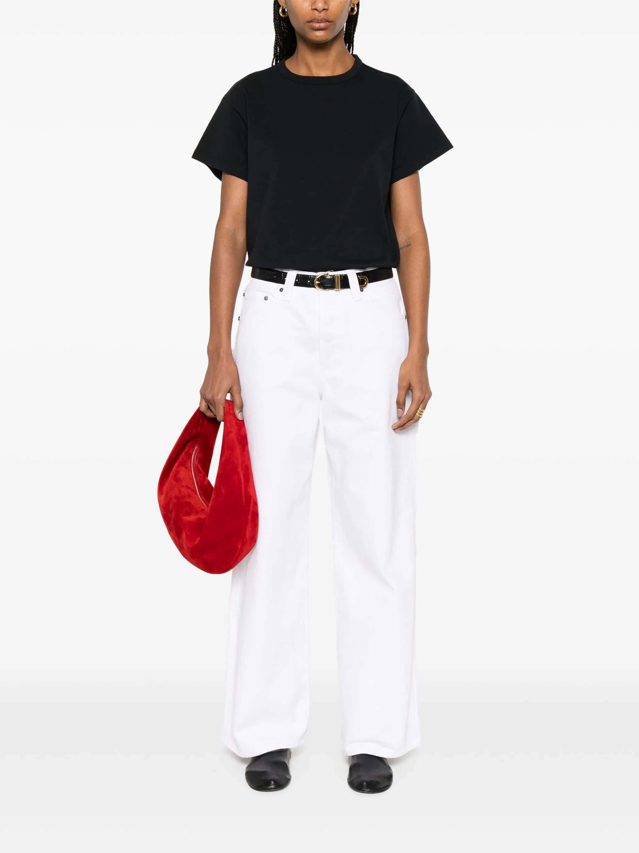 1. Sapato preto elegante com calças brancas e bolsa vermelha vibrante.